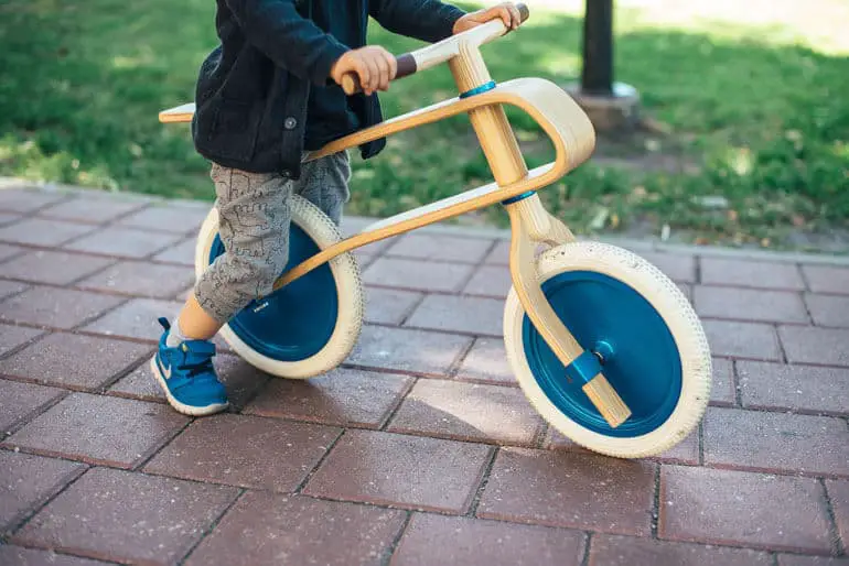 bot riding stylish wooden balance bike