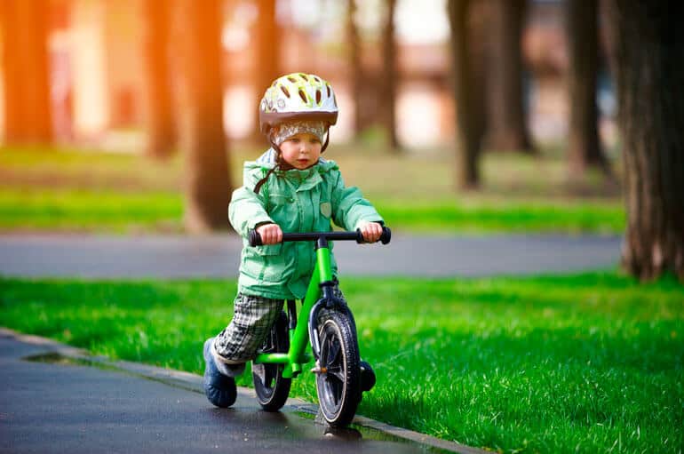 boy in helmet riding green matching bike