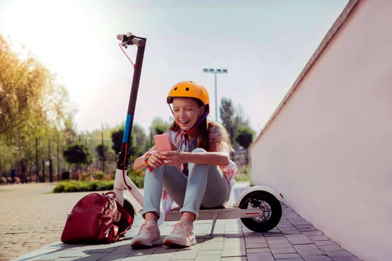 girl sitting on scooter chatting on phone